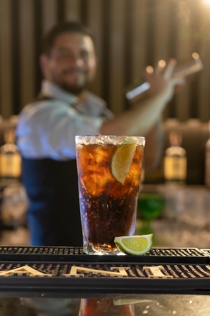 Foto een glas whisky op een bar met een man erachter