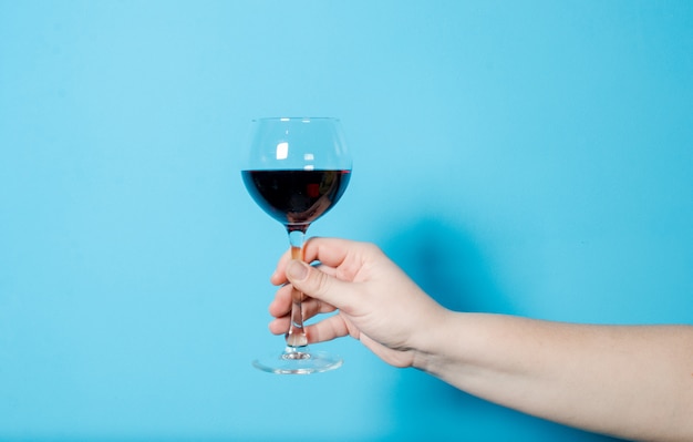 Een glas wijn in de hand van een vrouw. alcohol feest.