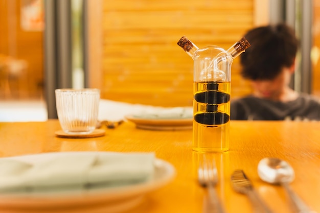 Een glazen fles met olijfolie en balsamico-azijn op de eettafel