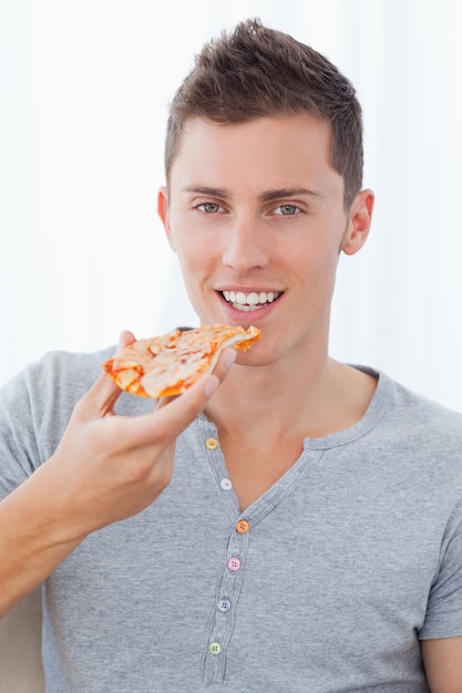 Een glimlachende pizza van de mensenholding aangezien hij op het punt staat te eten