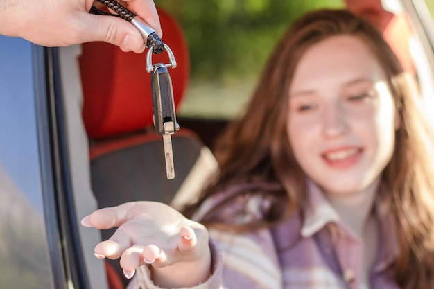 Een glimlachende vrouw neemt de autosleutels Autoverkoop en verhuur Auto-industrie