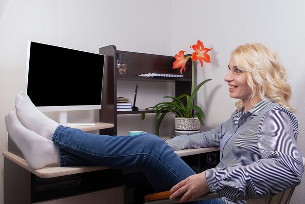 Een glimlachende vrouw werkt thuis op een computer Freelance werk