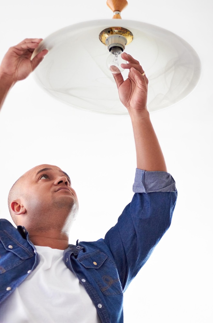 Foto een gloeilamp bevestigen laag zicht op een klusjesman die een gloeilamp bevestigt