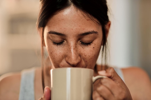 Een goede dag begint met goede koffie shot van een jonge vrouw die thuis geniet van een kopje koffie