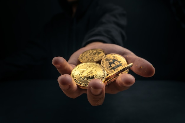 Een gouden bitcoin in de hand van een mysterieuze man, digitale financiën