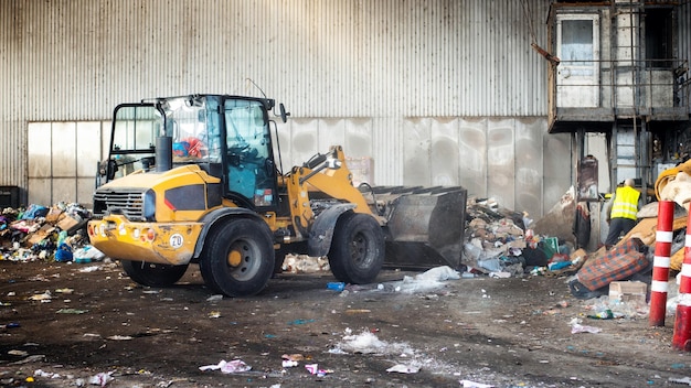 Een graafmachine aan het werk in een afvalsorteerinstallatie