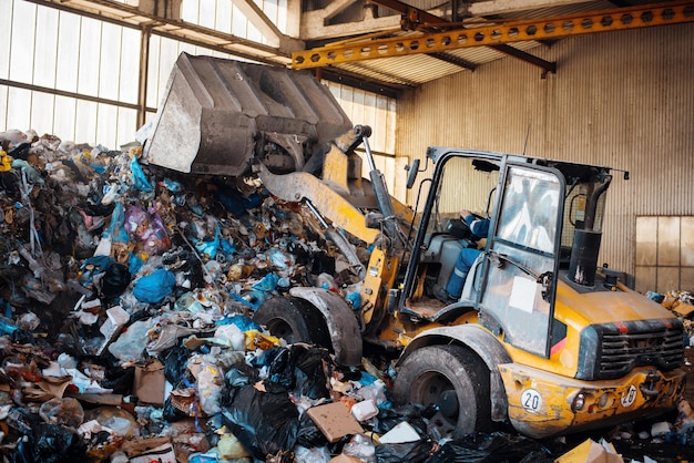 Een graafmachine aan het werk in een afvalsorteerinstallatie