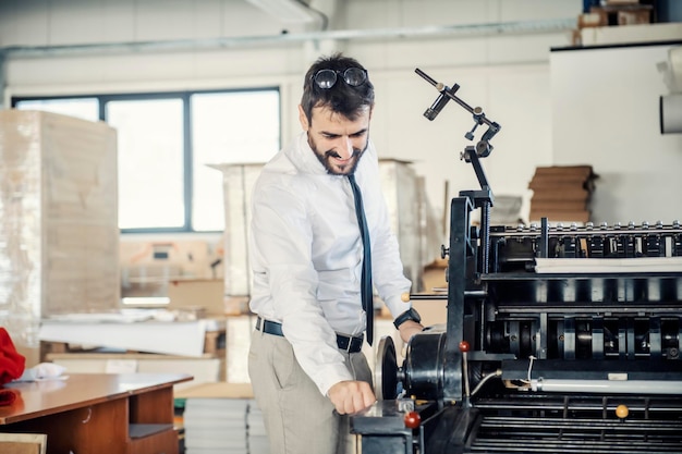 Een grafisch ingenieur die de drukmachine aanpast in de drukkerij