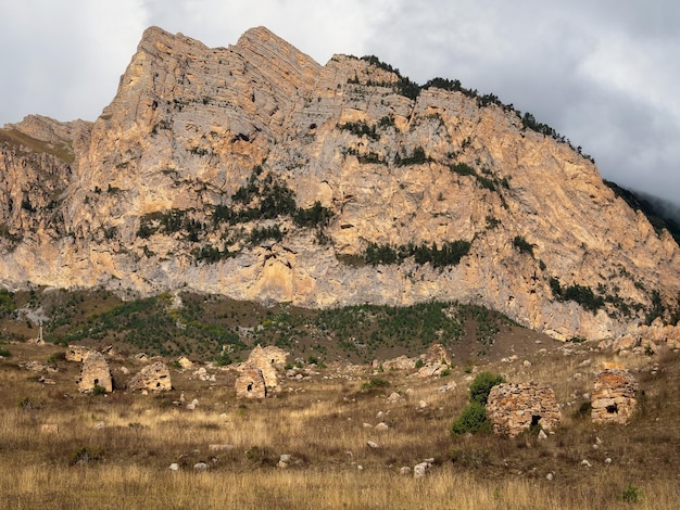 Een grafstenen stad onder een grote rots Oude Ossetische familiecrypten in de mistige regio Digoria in de bergen