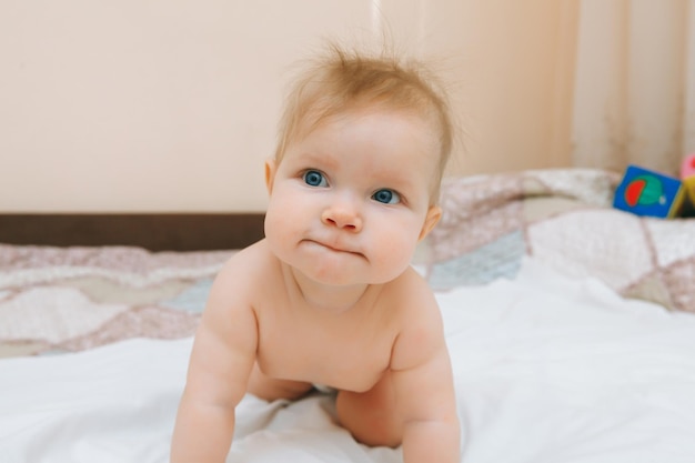 Een grappige baby die thuis in de kinderkamer kruipt, de baby is 6 maanden oud en leert kruipen