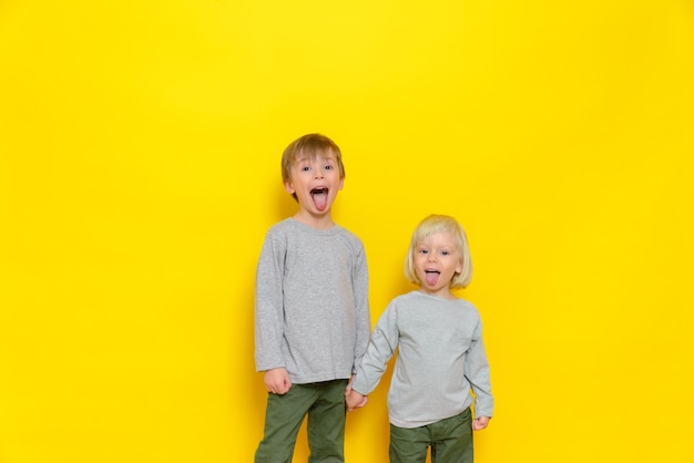 Een grappige jeugd van twee jongens die grijnzen en plagen en hun tong laten zien