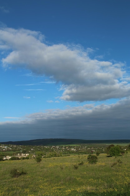 Een grasveld met een blauwe hemel en wolken boven