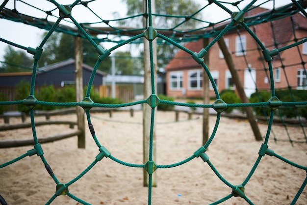 Een groen speeltoestel op een school op een regenachtige dag