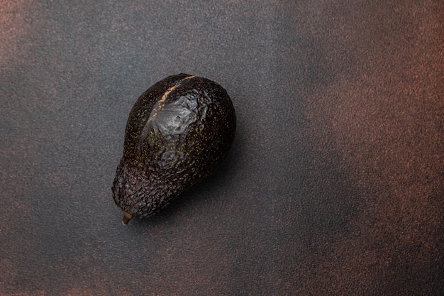 Een groene avocado op een donkere achtergrond