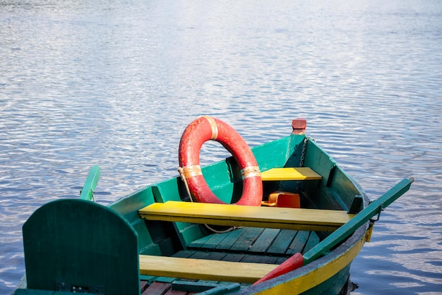 Een groene boot met een rode reddingsvest aan de zijkant.