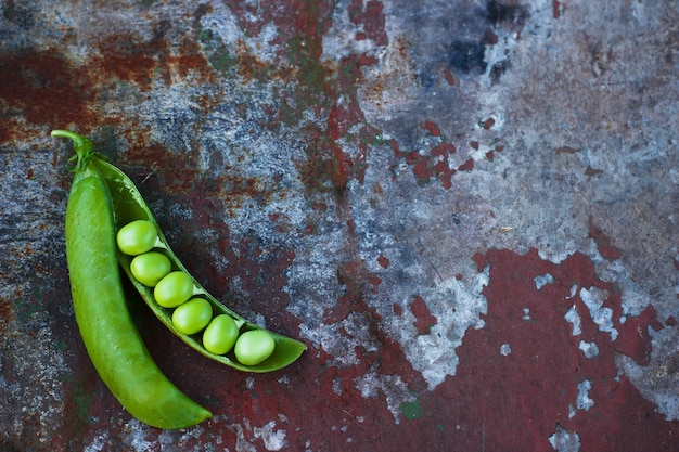 Een groene erwten op een roestige tafel