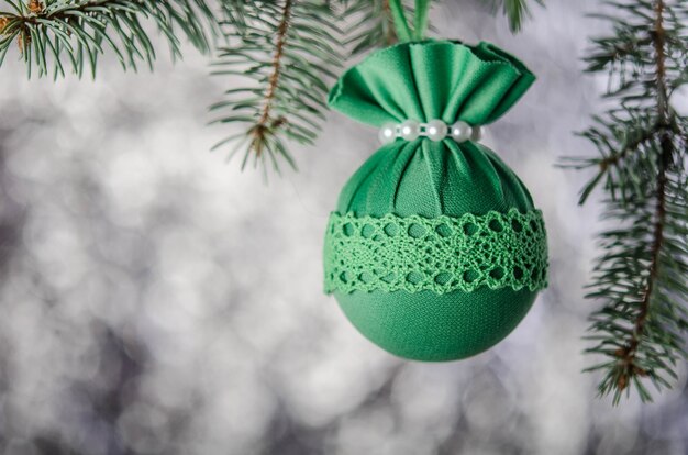 Een groene kerstbal op een nette tak. Nieuwjaarsdecoratie.