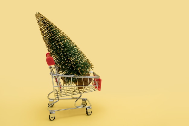 Een groene kerstboom in een supermarktkar.