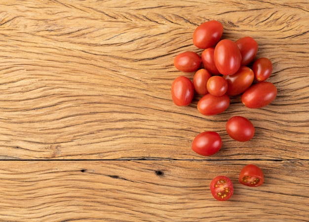 Een groep cherrytomaatjes over houten tafel met kopieerruimte.