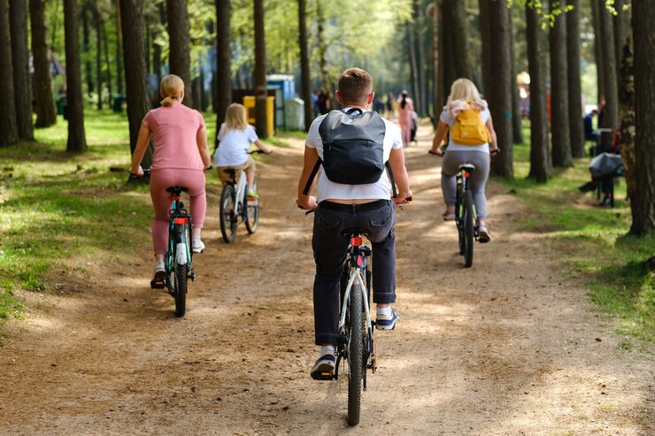 Een groep fietsers met rugzakken fietsen op een bosweg en genieten van de natuur
