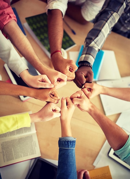 Een groep internationale studenten die een vuiststoot maken.