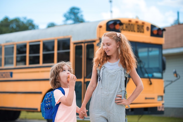 Een groep jonge kinderen stapt op de schoolbus.