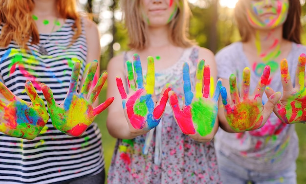 Een groep jonge meisjes toont handpalmen vies met gekleurde vingerverven