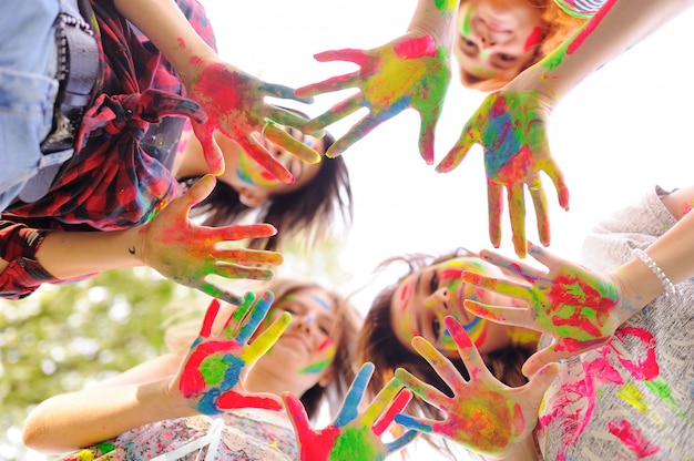 Een groep jonge meisjes toont handpalmen vies met gekleurde vingerverven