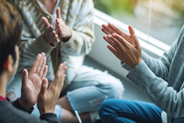 Een groep jonge mensen die in de handen klappen terwijl ze samen zitten