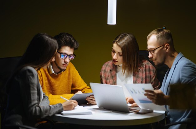 Een groep jonge ondernemers werkt samen in een creatief kantoor. Planningsanalyse werkt samen