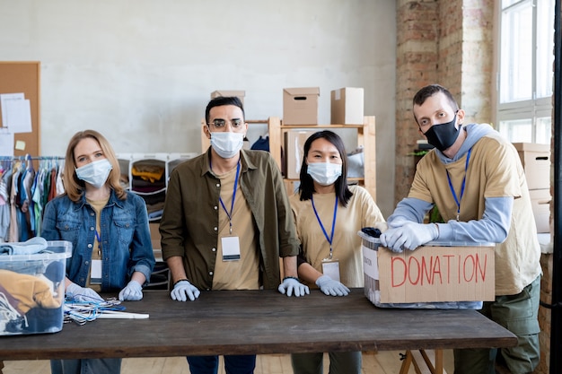 Een groep jonge vrijwilligers met beschermende maskers en handschoenen