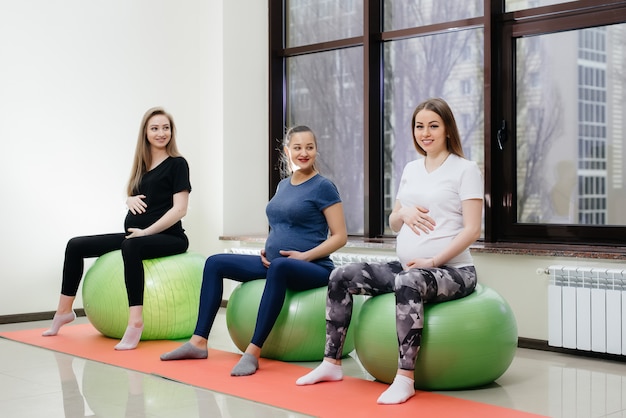 Een groep jonge zwangere moeders houdt zich bezig met Pilates en balsporten in een fitnessclub. Zwanger