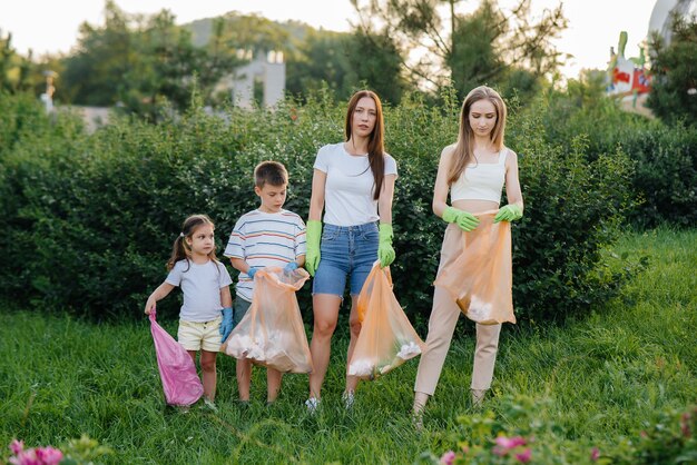 Een groep kinderen met hun ouders is bezig met het ophalen van afval.