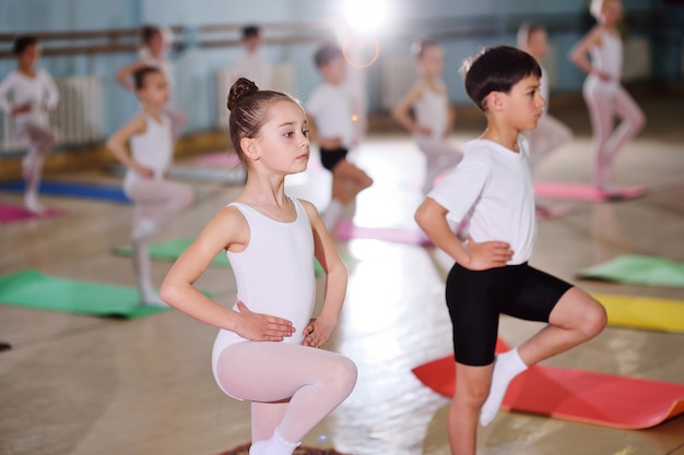 Een groep kinderen op een balletschool of in een gymnastiekafdeling over carimat