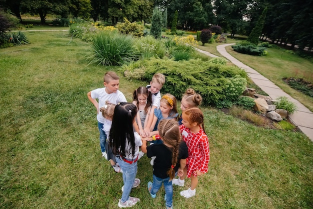 Een groep kinderen rent rond, vermaakt zich en speelt als een groter team in de zomer in het park. gelukkige jeugd.