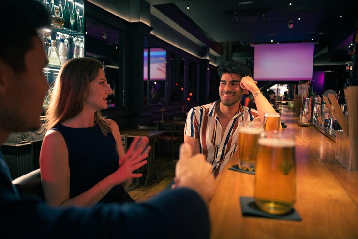 Een groep mensen die aan een bar zitten.