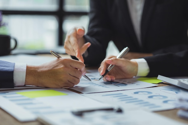 Een groep mensen die naar papieren op een tafel in een vergaderruimte wijst, een financieel analist die een bedrijfsauditvergadering bijwoont met de financiële en boekhoudafdeling Meeting concept