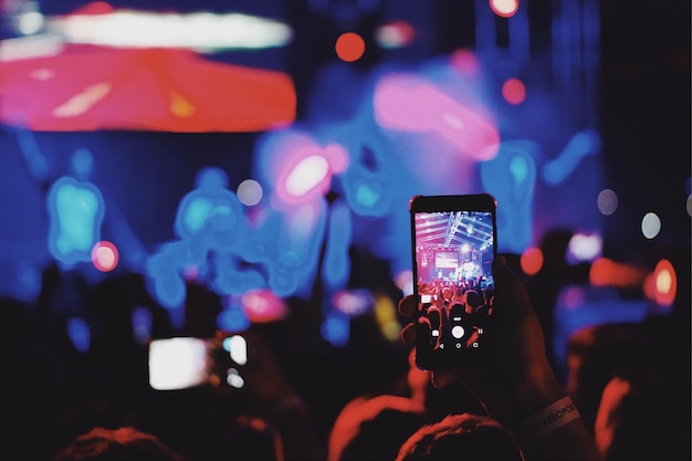 Een groep mensen die tijdens een muziekconcert fotograferen