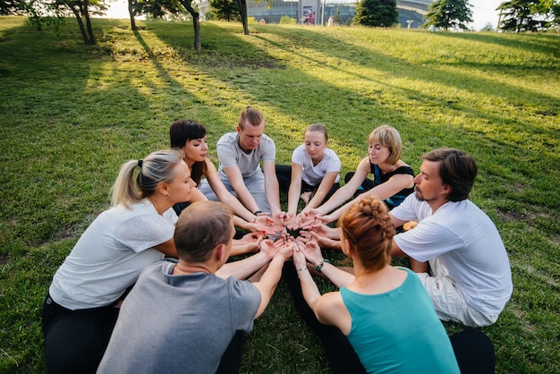 Foto een groep mensen doet tijdens zonsondergang yoga in een cirkel in de open lucht