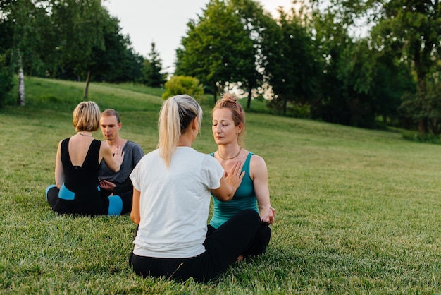 Een groep mensen voert gepaarde yoga-oefeningen uit in een park