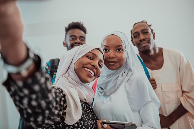 Een groep multi-etnische studenten maakt een selfie met een smartphone op een witte achtergrond. Selectieve aandacht. Foto van hoge kwaliteit