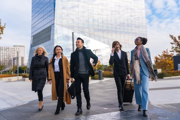 Een groep multi-etnische zakenmensen op het bedrijventerrein die naar het werk lopen