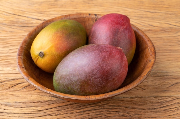 Een groep rijpe mango's over houten tafel