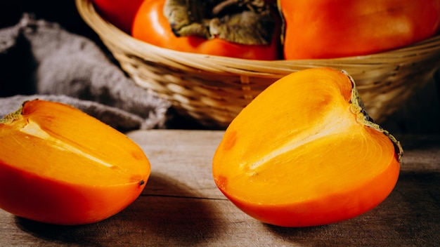 Een groep rijpe oranje persimmonvruchtenPersimmonvruchten op een houten plank rustieke achtergrond