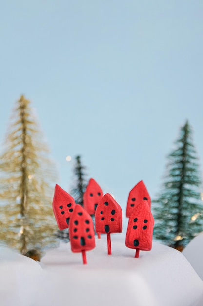 Een groep rode huizen staat in de sneeuw met een kerstboom op de achtergrond.