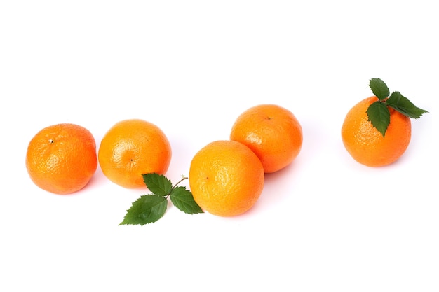 Een groep sappige oranje mandarijnen met greens op een witte achtergrond.