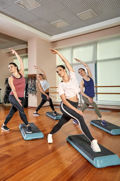 Een groep sportieve jongeren in sportkleding in een fitnessruimte die pushups of planken doet in de sportschool Groepsfitnessconcept groepstrainingen motivatie