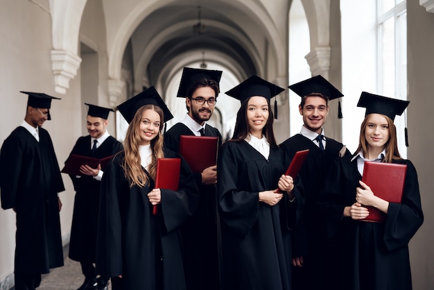 Een groep studenten in mantels staat in de gang.