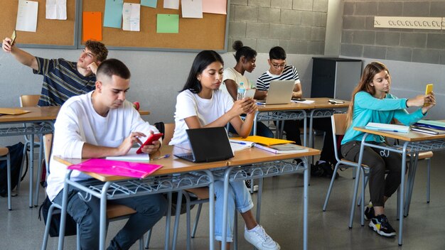 Foto een groep studenten zit aan een tafel met laptops en papieren erop