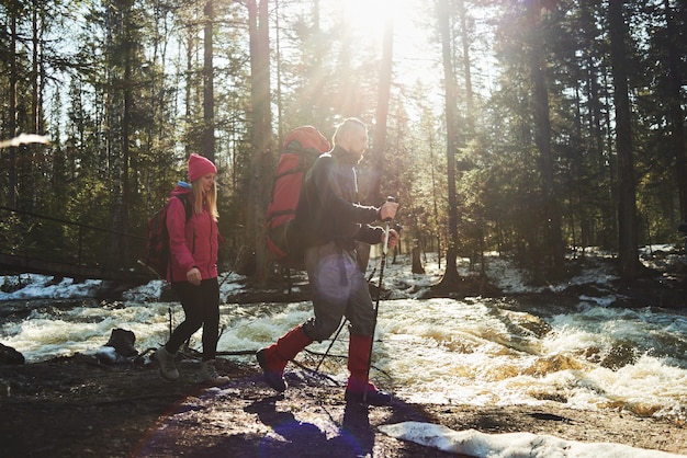 Een groep toeristen bestaande uit jongens en meisjes die in de bossen langs de rivier gaan